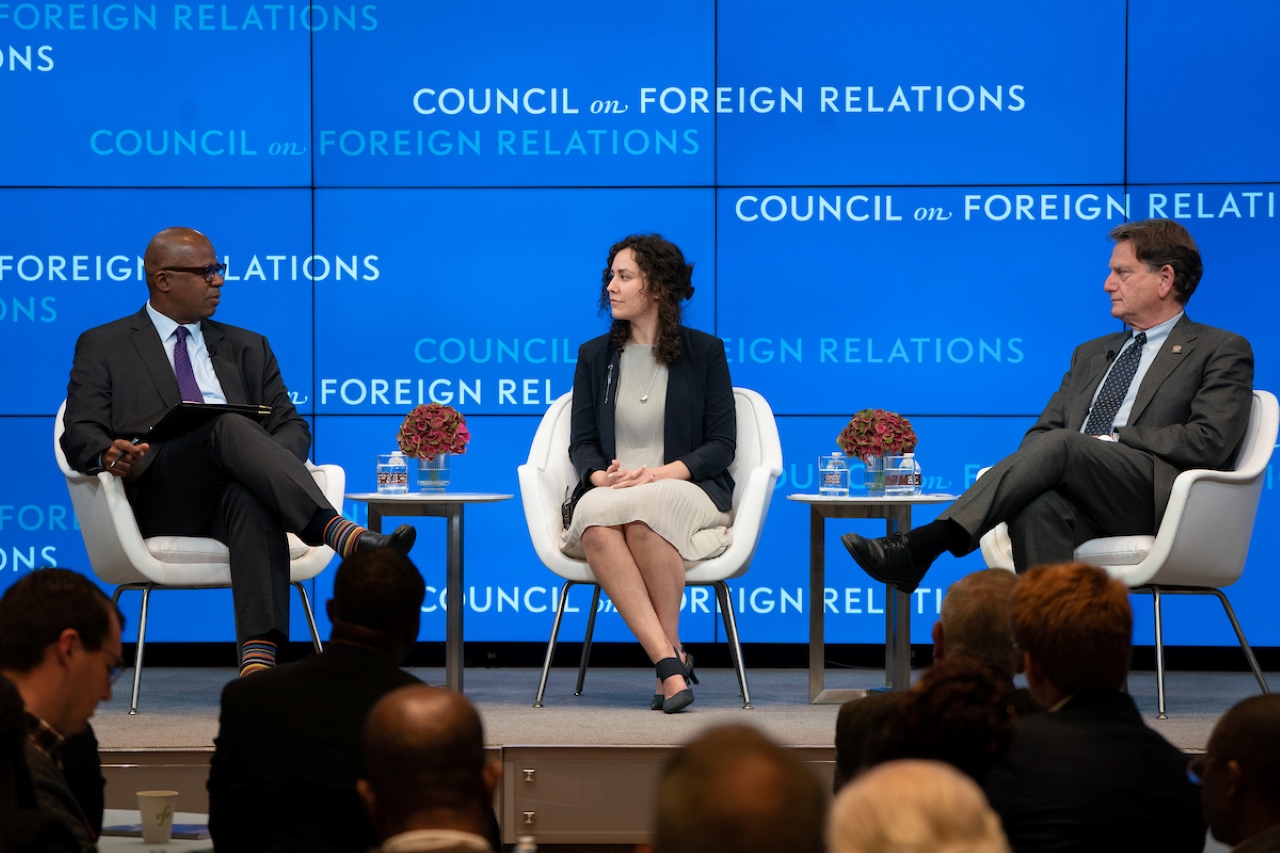 Three panelists speaking on stage at the workshop. 